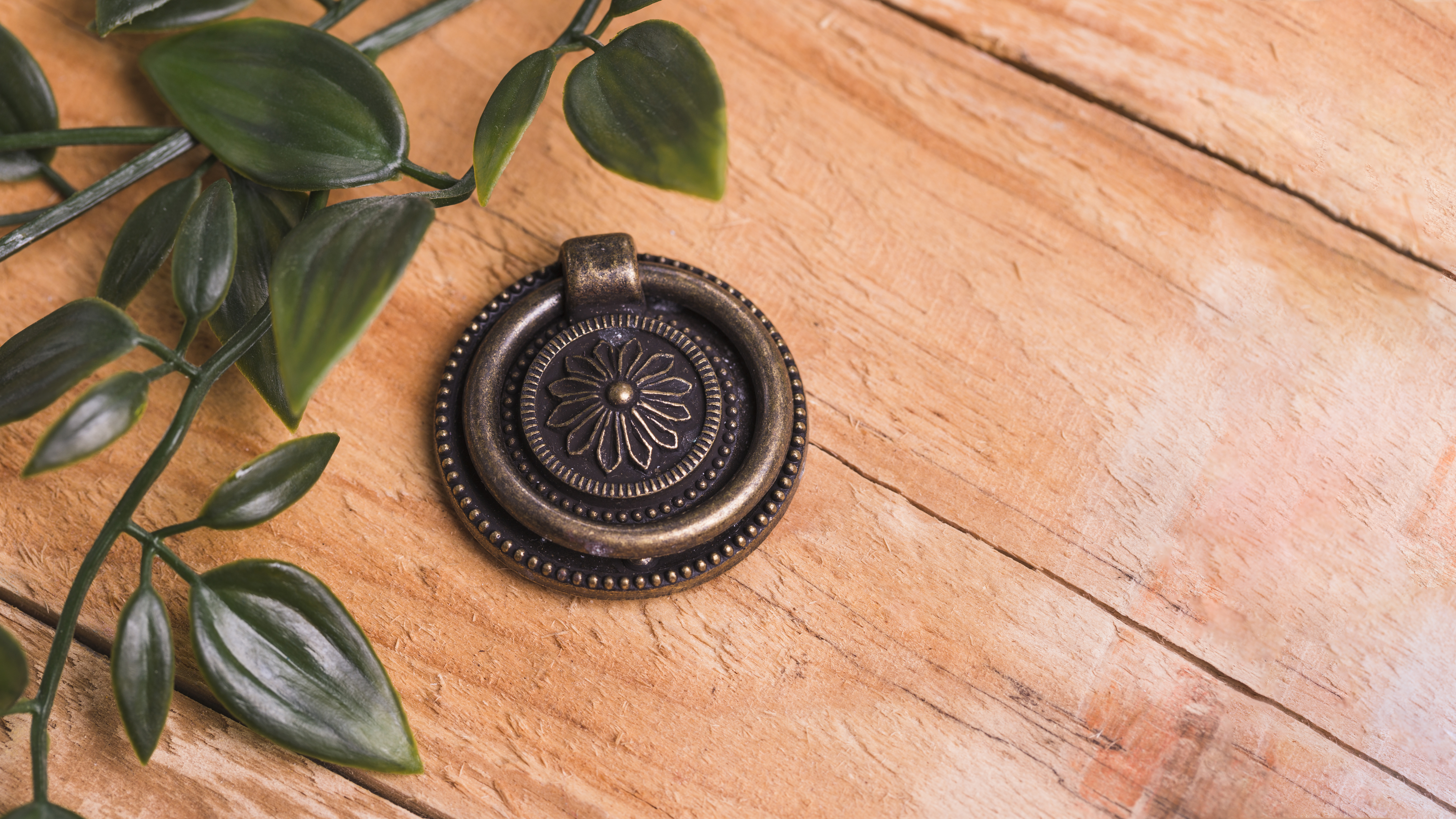 Metallisches Ornament mit Blättern auf warmer Oberfläche